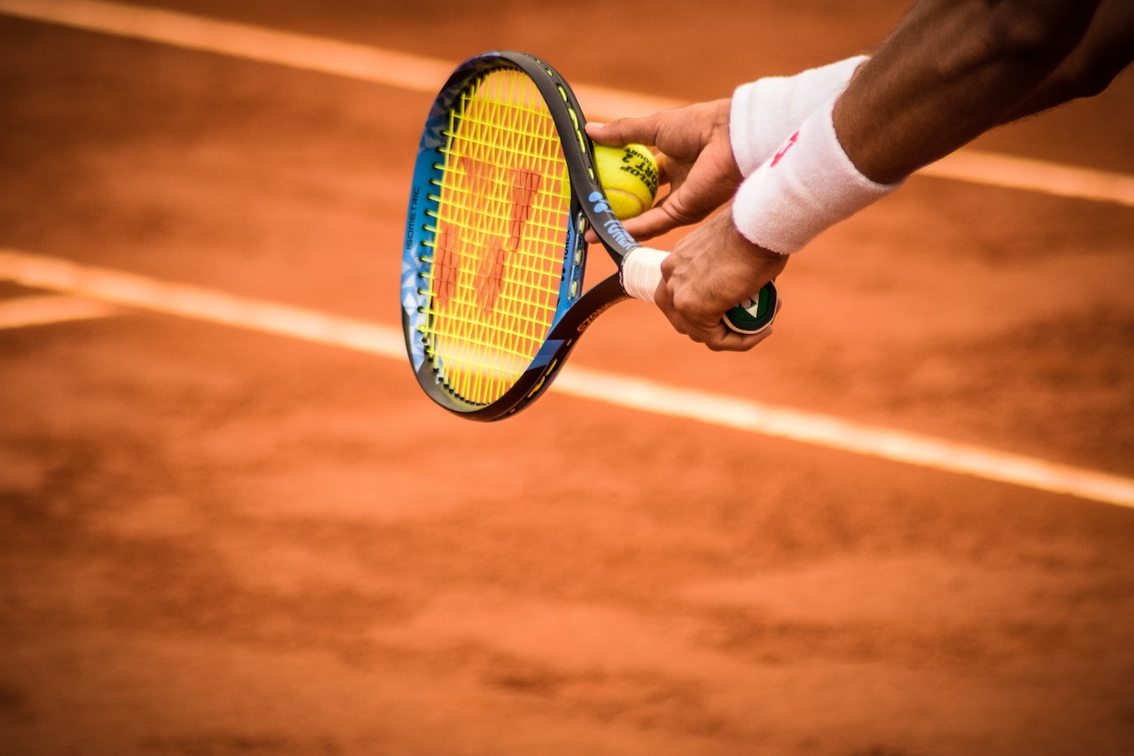 holding tennis racket and ball